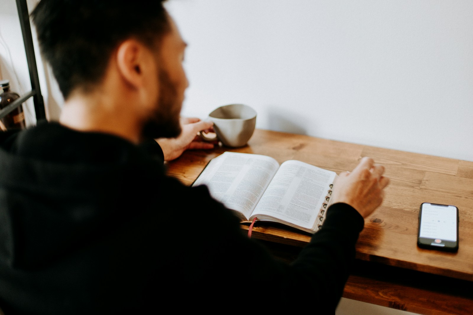 Photo by Priscilla Du Preez 🇨🇦 man in black long sleeve shirt writing on white paper
